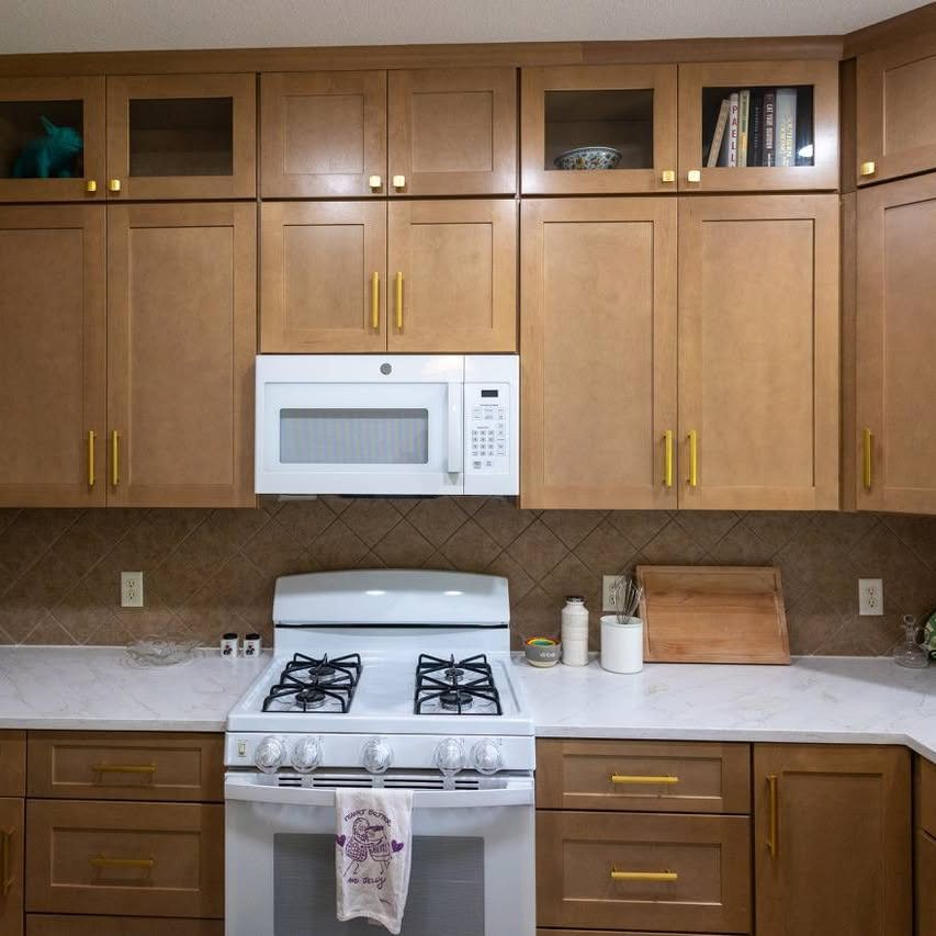 Kitchen with shaker cabinets, brass hardware, and quartz counters